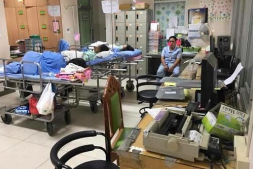 Patients lie on beds in what appears to be a staff office. 