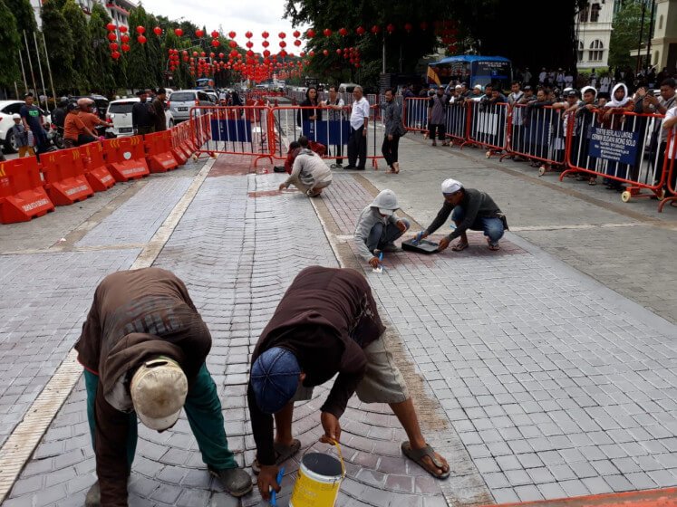 Workers paint over a road mosaic in front of the Surakarta City Hall in Central Java after Muslims groups complained that the street art resembled a Christian cross. (JP/Ganug Adi Nugroho)