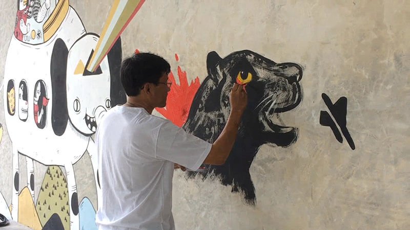An artist paints a mural to commemorate the black panther killed by Premchai Karnasuta at Rungsrit Kanjanavanit’s Chiang Mai home.