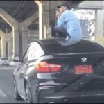 Driver Sits On Car Roof After Crash