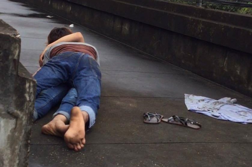 Police hunt couple filmed romping in the rain on motorway bridge