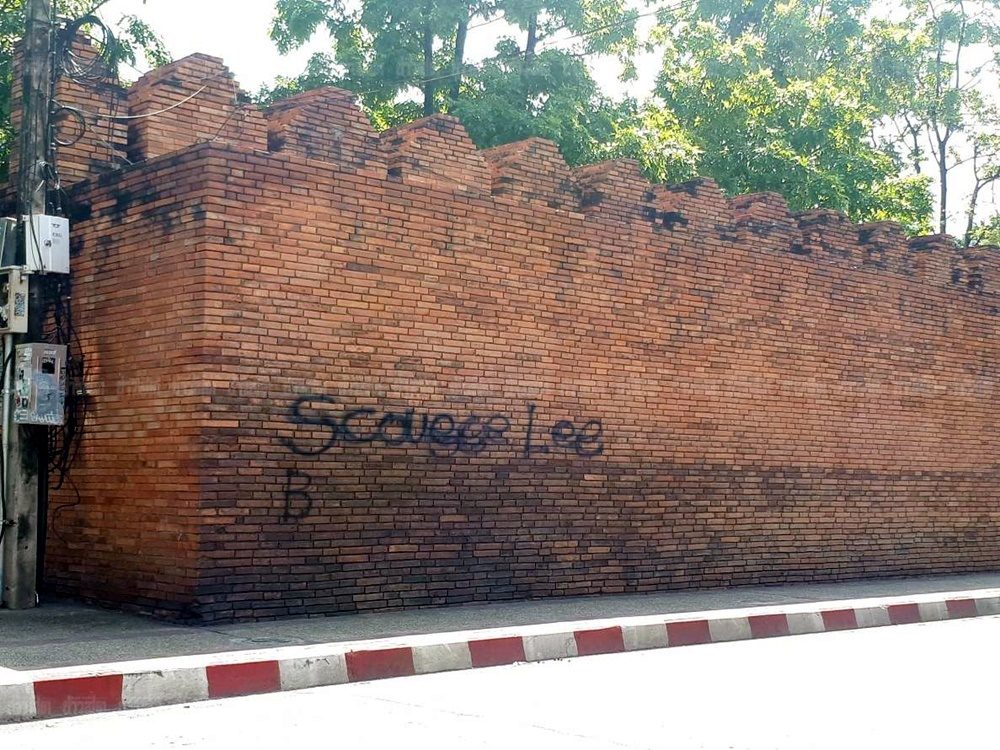 Chiang Mai police on Saturday said the two tourists who vandalized a historic wall avoided jail time and will likely fly home after paying 100,000 baht fines.  Col. Teerasak Sriprasert of Chiang Mai City police today said Briton Lee Furlong and Canadian Brittney Schneider were initially sentenced to two years in prison and 200,000 baht fines for tagging a wall at the city’s historic Tha Phae Gate. Their sentences were halved as they confessed.  Read: Farangs Face Hard Time For Chiang Mai Vandalism  Rather than jail time, both were given two years of parole, Teerasak said. He doesn’t know whether they are allowed to fly back home, but following protocol, they will be released after paying the fines.  Furlong and Schneider, both 23, were arrested hours after the wall was seen with “Scouser Lee B” in black spray paint on it last month. “Scouser” is British slang for a Liverpool native. Furlong is originally from Liverpool.  The maximum penalty for vandalizing a historical site is 10 years in jail and a 1 million-baht fine.  Tha Phae Gate is believed to be originally built in 1296. The gate and wall seen today is a product of reproduction in 1985 based on a photograph of the gate from 1879.
