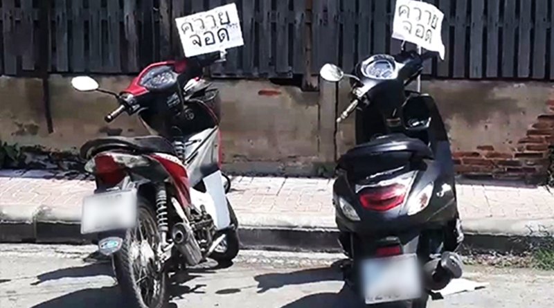 Angry Auntie sticking hate signs on motorbikes in public road.