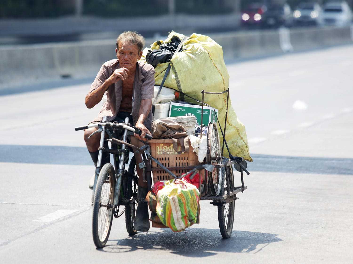 A scrap metal dealer rides his tricycle. Calls are being made for more face masks and sanitiser gel to be made available to needy people. (Photo by Apichit Jinakul)